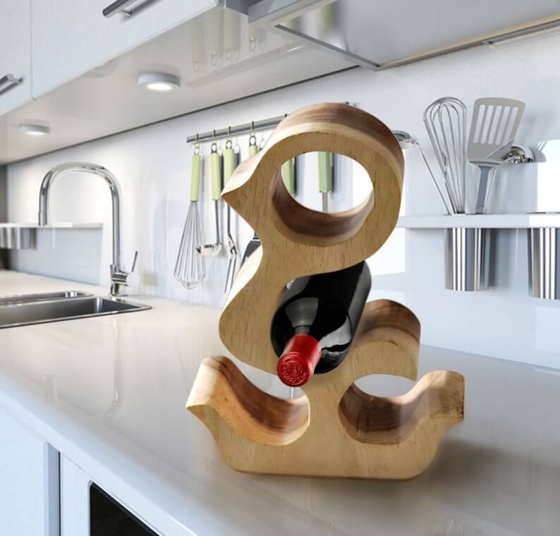 Wooden wine bottle holder shaped like an ampersand on a kitchen counter.