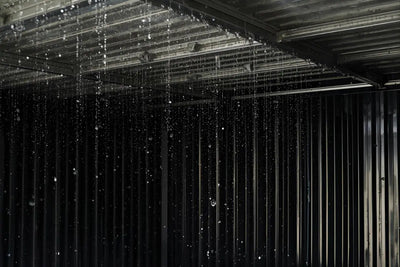 Condensation droplets inside metal shed roof with storage boxes below showing moisture damage prevention solutions