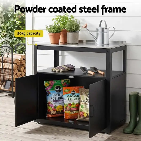 Gardeon potting bench storage cabinet open showing potting mix and garden tools