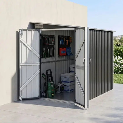 Giantz lean-to shed installed against backyard fence with two adult bikes and garden tools inside