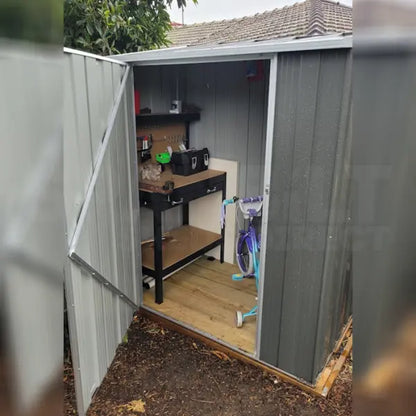 Interior shelving installed vertically in tall narrow shed showing organized tool and equipment storage zones
